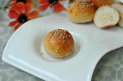 A small bread with meat and sesame seeds