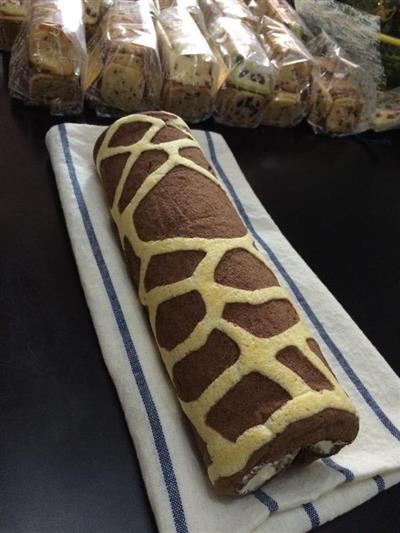 A basket of pork and a long giraffe cake roll.